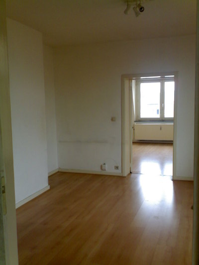 The bedroom seen from the kitchen through the living area